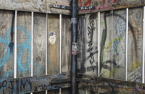 "Fence (JFK version)," 2013, Wood, metal, ink, marker pen, tippex, tape, dirt, crayon, paper, spray paint, graphite, Long section: 168 x 59 x 6 inches, Short section: 108 x 59 x 6 inches, Image courtesy gallery website