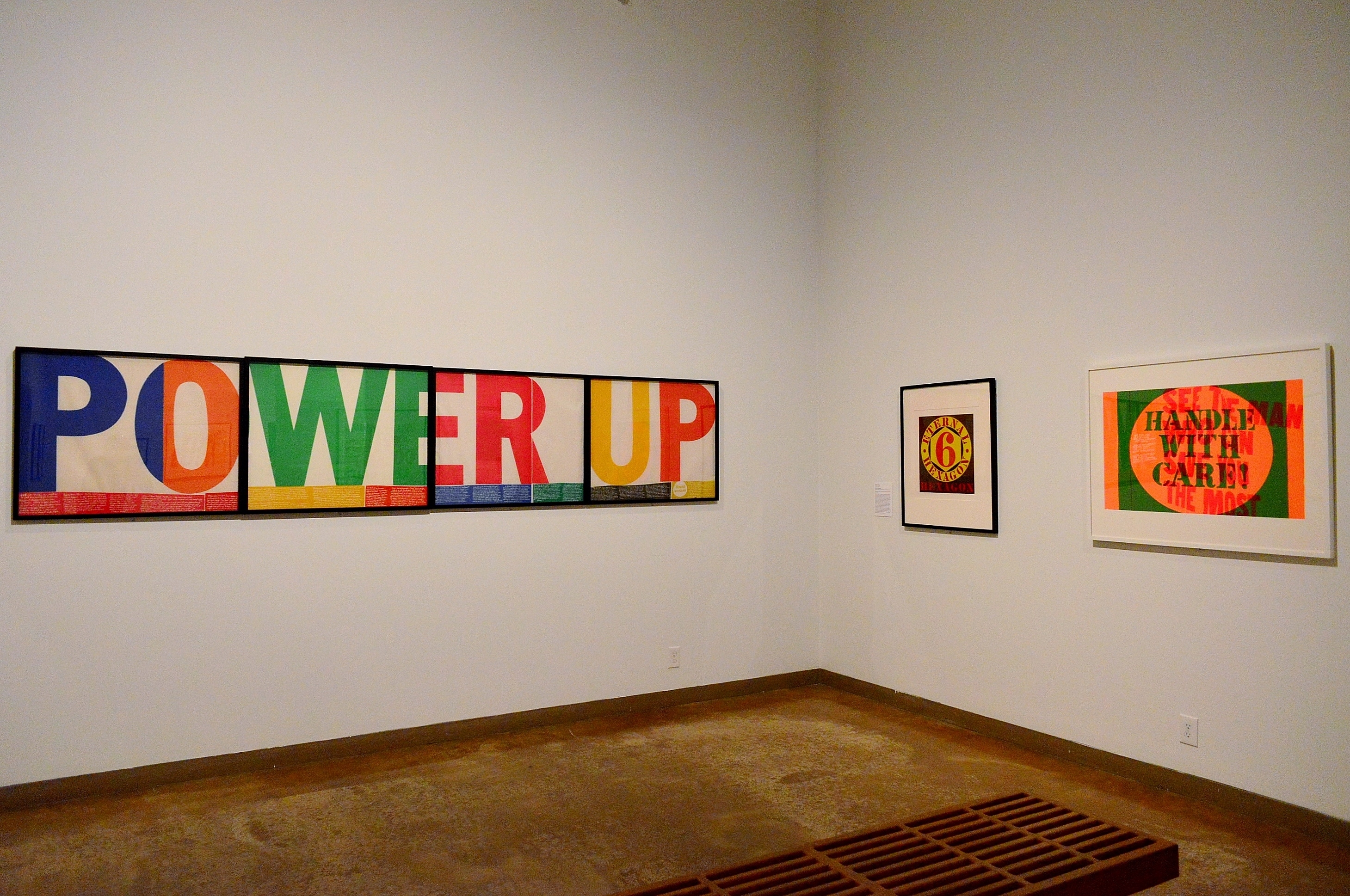 External Hexagon by Robert Indiana (c) flanked by two Corita Kent works power up (r) and handle with care (l).