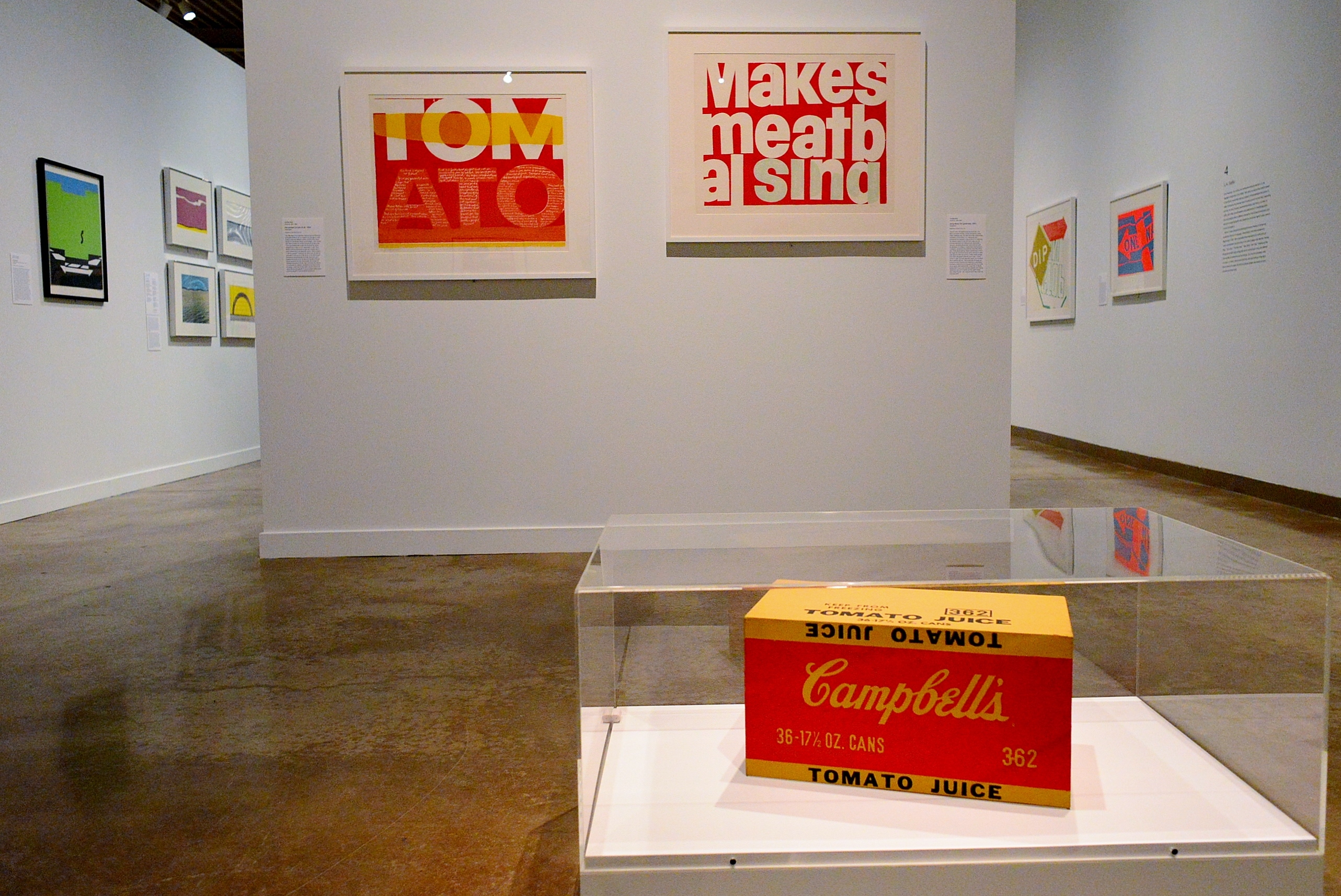 the juiciest tomato of all and song about the greatness (l-r) by Corita Kent. Andy Warhol’s Campbell’s Tomato Juice  Box (foreground)