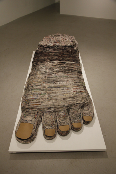 Barefoot and Pregnant, 2013, cut and stacked newsprint, cardboard, glue, 18 x 36 x 72 inches
