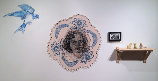 Beth Secor, This is terrible (this is sublime), Drawing of Shirley Secor in ink and White Out on vellum with embroidery, on found embroidery with beads (2013), photograph of Shirley Secor (nee Marrs) and Clara Marrs (1946), sulfur lion statue with broken head from Gulf Sulfur Company (1962); antique dog statue from Japan with hole in head (date unknown); saint statue from Mexico with head knocked off (2004)