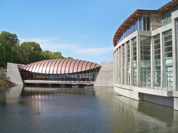 Large museum buildings are situated on a waterway.