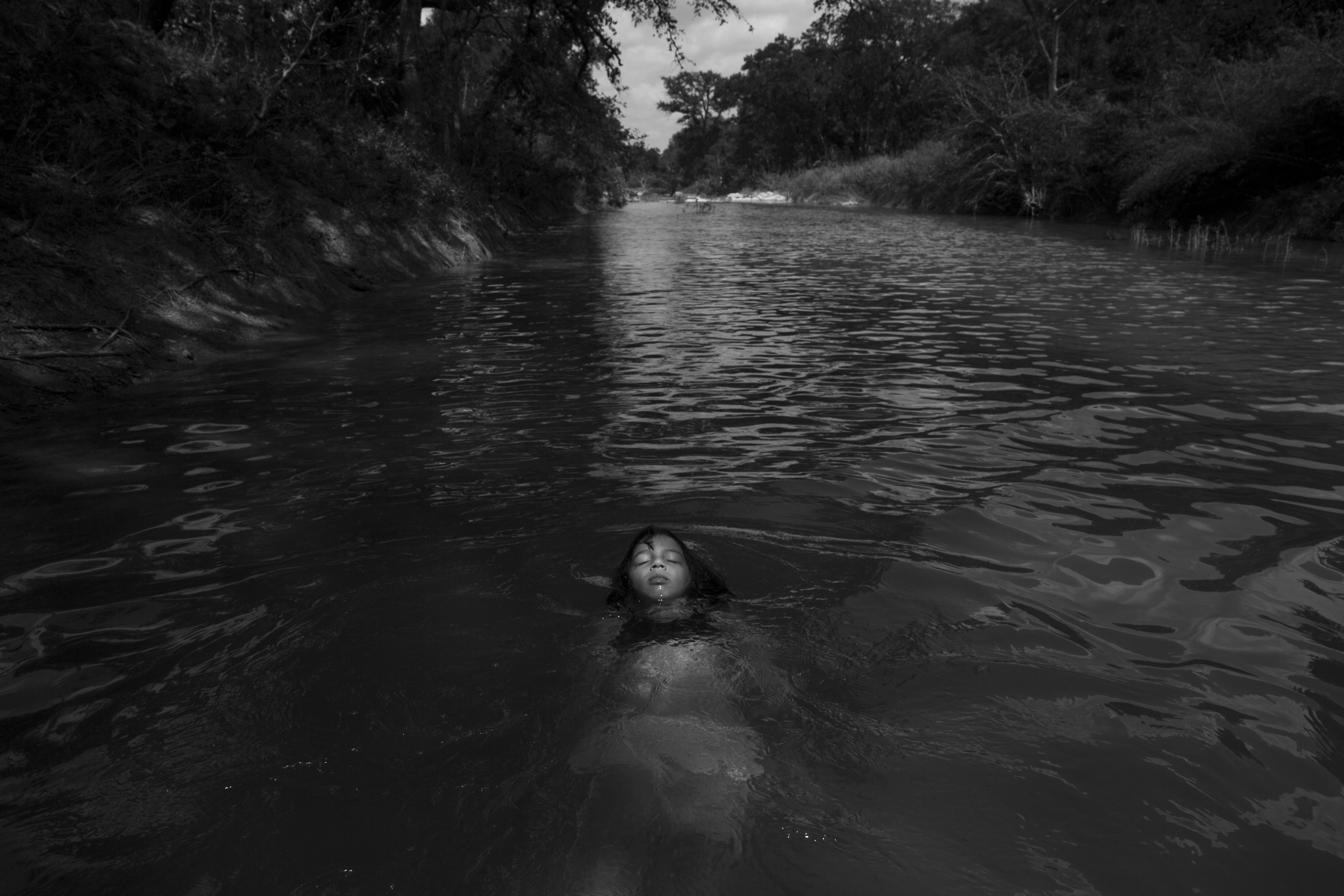 Photo by Carolyn Van Houten. "Serenity Bamberger floats in the Little Blanco River along their property on August 18, 2015 in Blanco, Texas. Three months prior, over Memorial Day, the same river flooded their home and business destroying the majority of the family's belongings and source of income. The Memorial Day weekend flooding, which affected Texas and Oklahoma, killed 24 people according to The Associated Press."