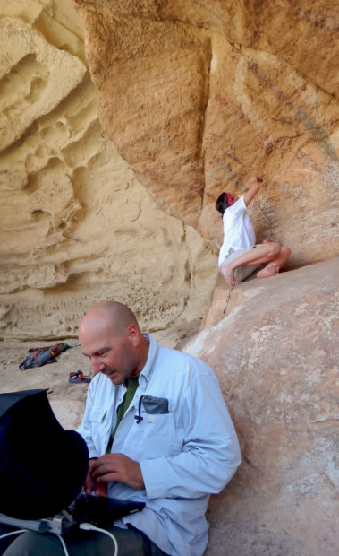 Archaeologists working with a digital field microscope. With the microscope placed at the analysis location, the microscope is connected via USB to a laptop where the microscopic imagery is viewed and photographs are captured.