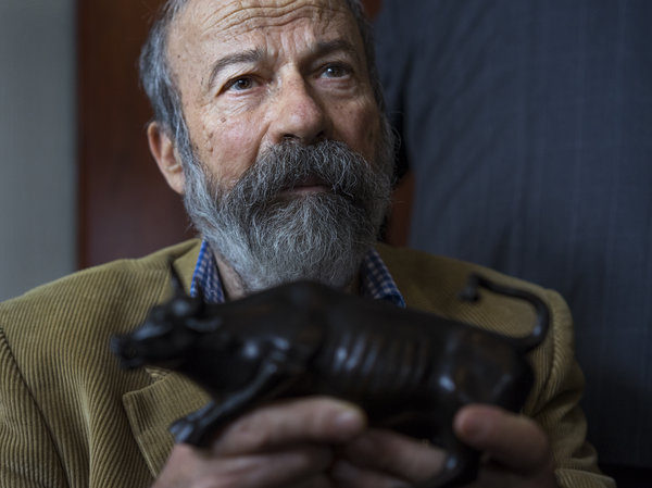Arturo Di Modica holds a model of his Charging Bull during a news conference Wednesday.