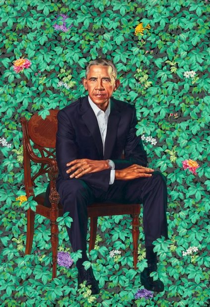 Retrato del expresidente Barack Obama. Viste un traje sin corbata y está sentado en una silla sencilla de madera frente a un fondo cubierto de follaje, crisantemos, jazmines y agapantos que se extiende hasta sus pies.
