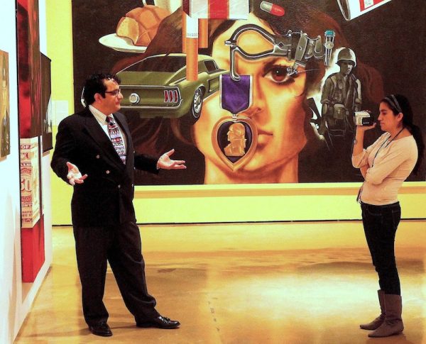 Educadora Mia Lopez graba video de Ruben C. Cordova en la retrospectiva de Treviño en el Museo Alameda en 2010. De derecha a izquierda: Mi vida (1971-72), Alamo Exit (1969), Zapata (1969), Armando Albarran (1968).