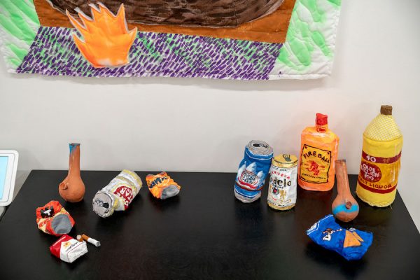 Various works by Alexis Mabry (mixed media alcohol containers, cigarettes, chips) and Steef Crombach (ceramic bongs). 