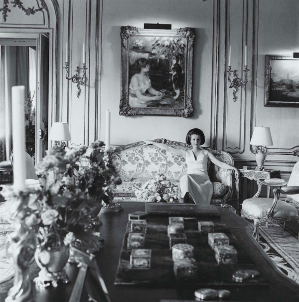 Jayne Wrightsman in her New York apartment, wearing a satin gown by Givenchy, sitting on a Louis XV cut-velvet sofa under Renoir’s Girl with Cat. An ebony Louis XV table signed b.v.r.b. (made for Mme de Pompadour and subsequently owned by the Duc de Richelieu) is in the foreground. It is topped with a collection of rare snuff-boxes. Photo by Cecil Beaton, 1966.