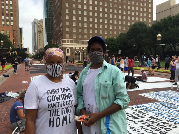 Artists Letitia Huckaby, left, and Sedrick Huckaby pose by their temporary street painting downtown Fort Worth, July 27, 2020. Photo Credit, Adam Werner