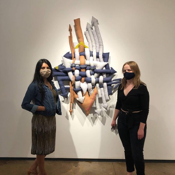 Martha Elena, left, and Evie Marie Bishop pose in front of Elena's work at Artspace 111