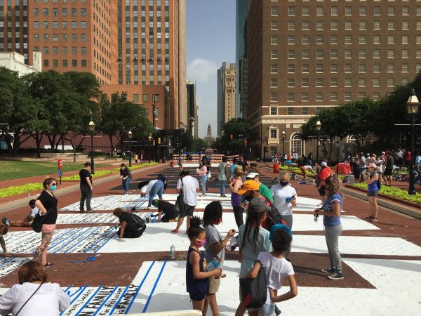 More volunteers paint their signatures onto Sedrick and Letitia Huckaby's temporary street painting downtown Fort Worth, July 27, 2020. Photo Credit, Adam Werner