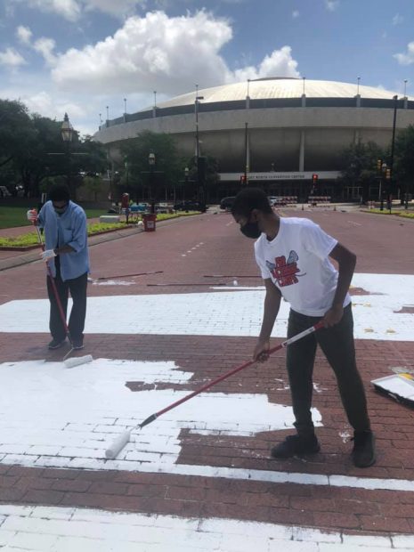 Sedrick Huckaby, Left, and his son paint END RACISM NOW downtown Fort Worth