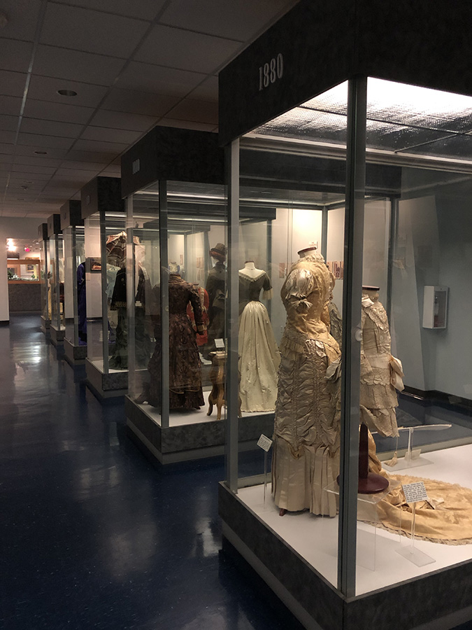 Rows of Victorian dresses from the Judy Richey's collection on display Confederat Flags on display-Texas-Civil-War-Museum-White-Settlement-TX