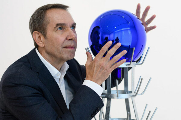 artist Jeff Koons poses with an orb artwork