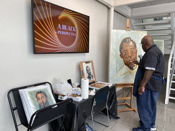 Artist Eddie Filer paints a portrait of James Baldwin at the Houston Museum of African American Culture's Juneteenth Celebration, 2021