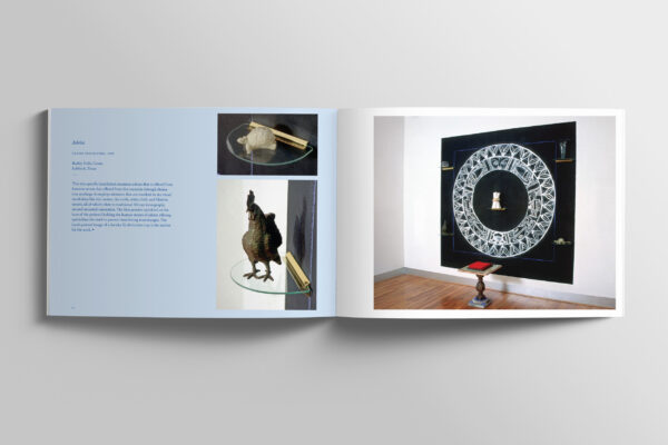 A spread of a catalog of the artwork of Vicki Meek. The spread features photographs of the artist's installations