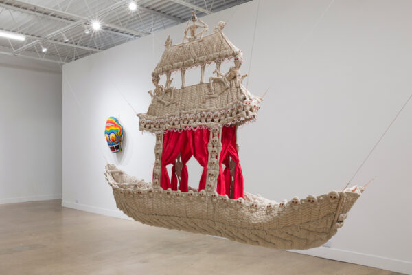 A sculpture by artist Nomin Bold, made of fabric. The sculpture is shaped like a ship and features skull ornaments.