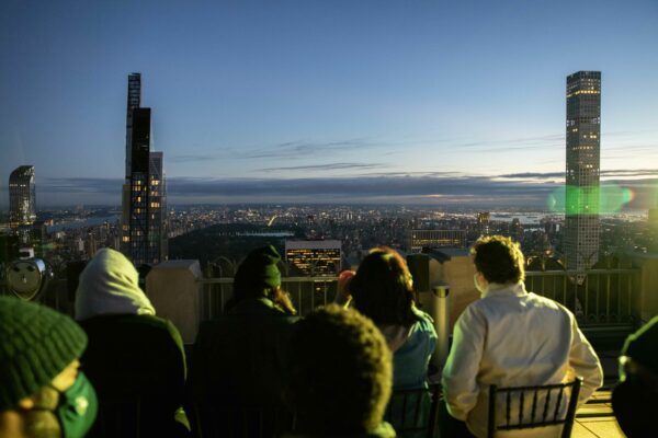 A performance of Andrés Jaque's performance piece Being Silica. The performance is happening on the top of Rockefeller Center, meaning that you can see the New York skyline in the background.
