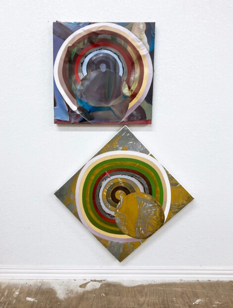 Two abstract paintings handing on a wall. The top painting is square shaped, and the bottom piece is also square, but hung to look like a diamond. The pieces look like shooting targets