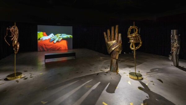 Installation view of Carolina Mesquita exhibition at the Blaffer Museum. Photo includes large metal sculptures of a human hand, a shrimp, and two organic shapes