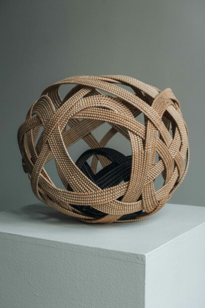 A sculptural piece by Donya Stockton. The sculpture is a round sphere with negative space made with the same technique of basket weaving