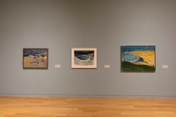 Photographs of Milton Avery's art show.  In the photo are three paintings hanging on a gray wall.