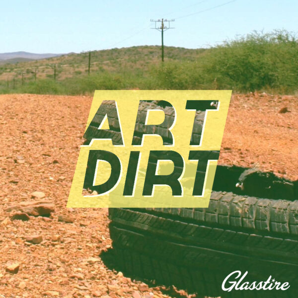 A logo for Glasstire's Art Dirt podcast. The image features the words Art Dirt in yellow, over a background of a photograph of a tire on a dirt road