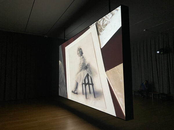 A photograph of a large screen with a projected image. Artwork by Teresa Hubbard and Alexander Birchler.