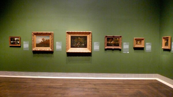 Exhibition view of Impressionist show with six paintings on a green wall