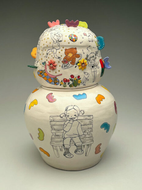 A photograph of a ceramic sculpture. The object is painted white with brightly painted illustrations. Artwork by Jihye Han.