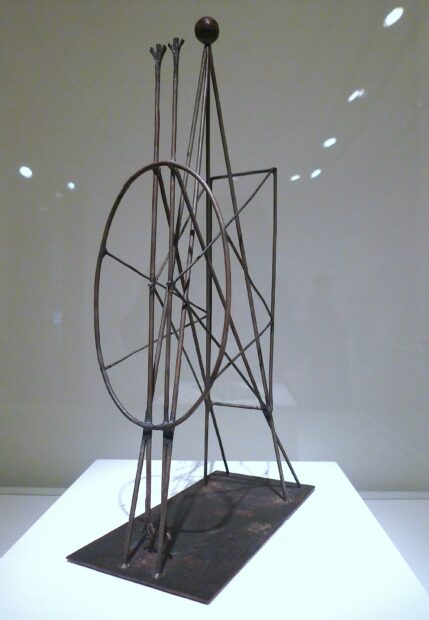 Photo of a sculpture work by Pablo Picasso. A metal piece with both round and geometric shapes connected by metal pieces