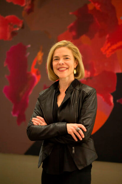 Portrait of Alison Weaver, director of the Rice Moody Center standing in front of a red backdrop