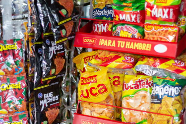 Varias marcas de papas fritas son exhibidas en la vidriera de una tienda en El Salvador