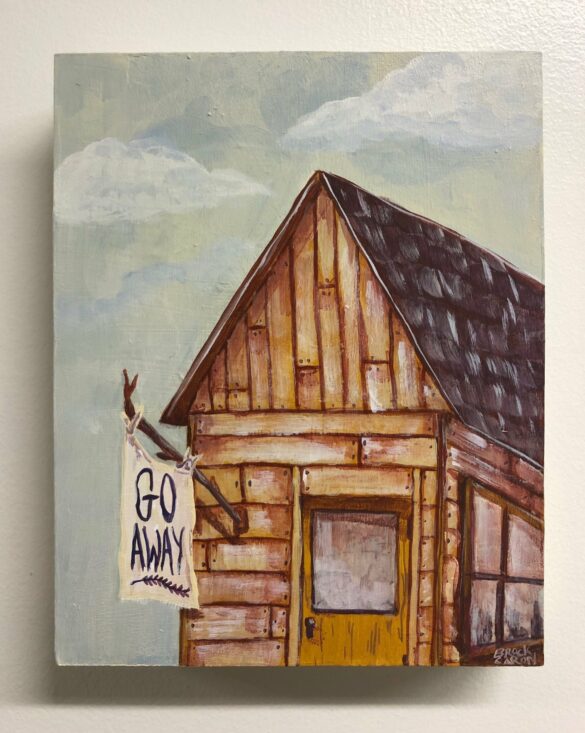 A photograph of a painting by Brock Caron. The painting depicts a small wooden cabin with one door and one window. A makeshift flag extends from the front of the cabin and reads, "GO AWAY." Behind the cabin is a pale blue sky with two white clouds.