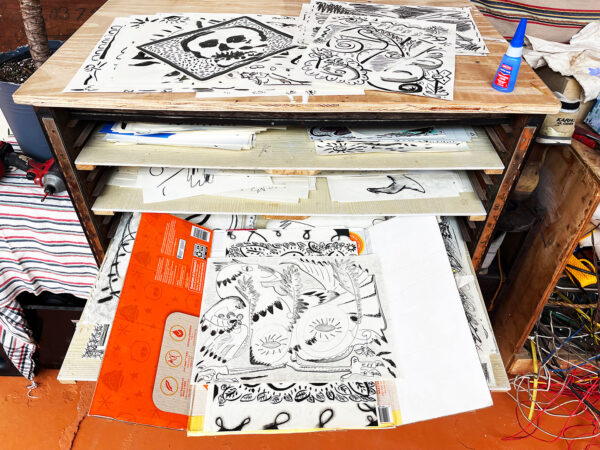 Photo of a flat file full of black and white drawings by Daniel Rios Rodriguez