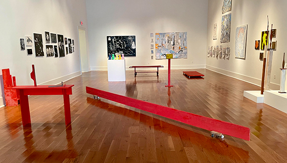 Installation view of the exhibition of Nick Barbee at the Galveston Arts Center. The image shows works on paper and paintings hanging on the walls and sculptures filling the center of the space