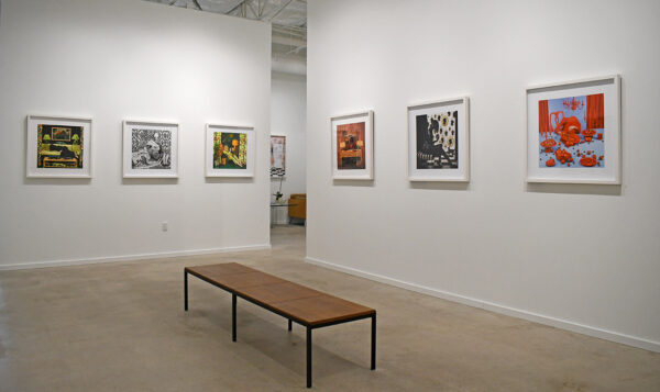 Installation view of the exhibition at PDNB with framed photos hanging in a row on a white wall.