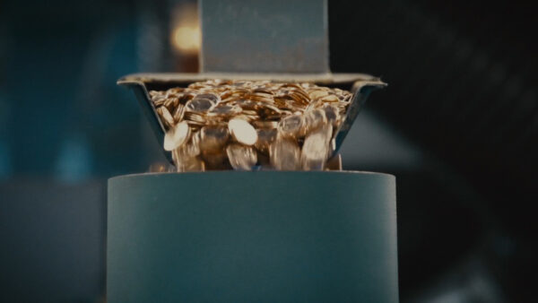 Image taken from a film still of hundreds of Pennies being dropped into a container