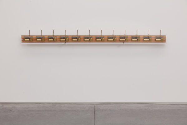 Image of a sound work by John Cage played by turning the lever of 12 mechanical boxes