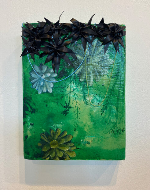 A small painting by Julon Pinkston. The artwork features a green background painted with thin layers of acrylic paint. Images of vines and plant life are painted throughout. At the top of the painting are seven three dimensional black flowers created from manipulated dried paint. 