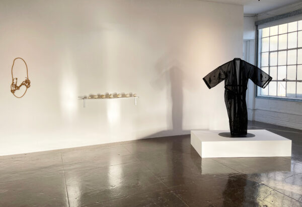 Exhibition image with work by three artists on the walls and on a plinth in the space.