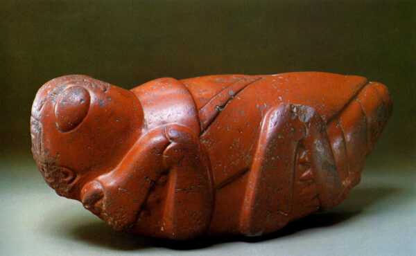 Red clay sculpture of a stylized grasshopper