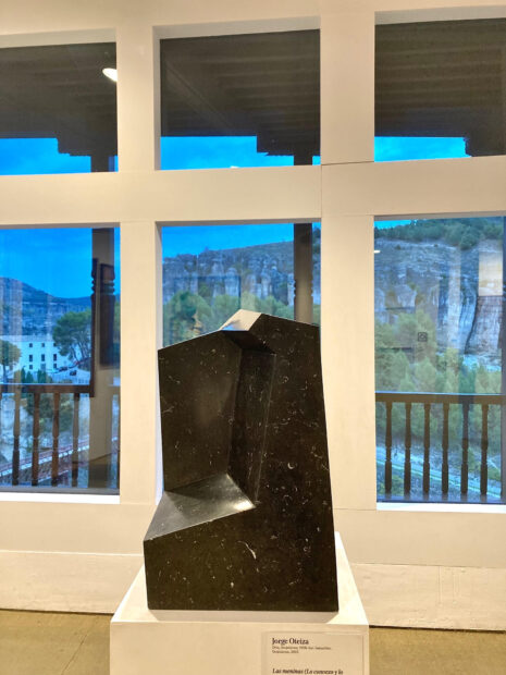 Installation view of a black, geometric, marble sculpture by Jorge Oteiza