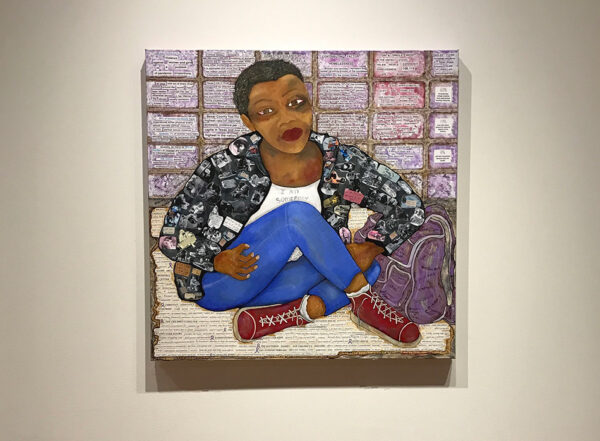 A photograph of a painting by Carmin Cartiness Johnson. The painting depicts a black woman seated on the floor with her legs crossed. She wears a white shirt with the words, "I am Somebody," written across the chest. The ground that she sits on and the wall behind her are filled with text.