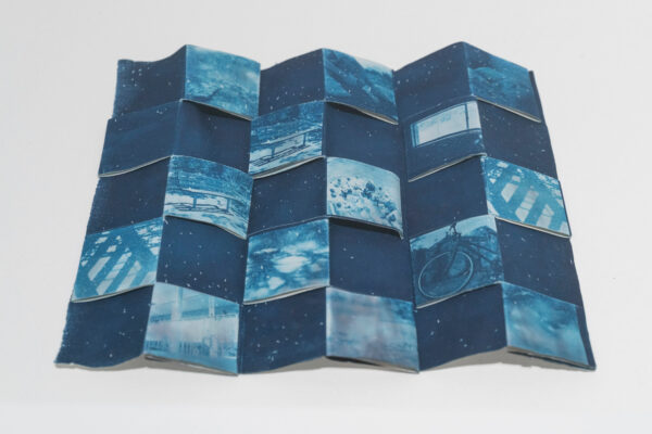 Image of an accordion style book of blue cyanotypes