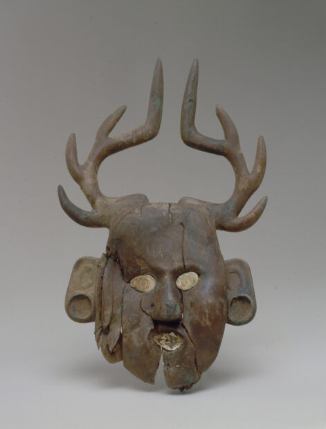 Antiquity of a carved wood effigy of a human face with deer antlers