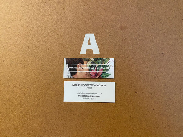 A close-up photograph of Michelle Cortez Gonzales' studio door. The door has the letter "A" and below that are two business cards with contact information for the artist.