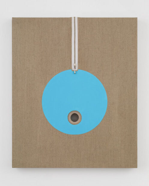 Raw cotton canvas on a stretcher with a blue circle int he center and a white zip extending from the top of the canvas to the top of the circle