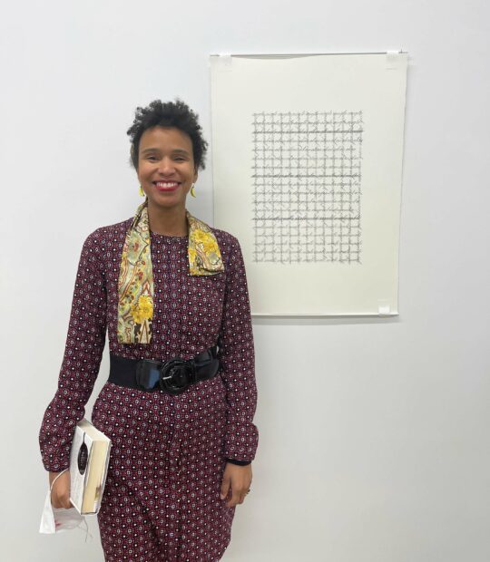 Photo of the artist Andrea Tosten standing next to a work on paper